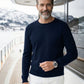 Man in navy colored Cashmere Premium Roundneck sweater standing on the yacht