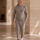 Ein Mann in einem Kaschmir Hoodie und Hose in Farbe Taupe