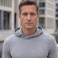 Ein Mann in einem Athletic Hoodie in Grau  [ai-mod-b]